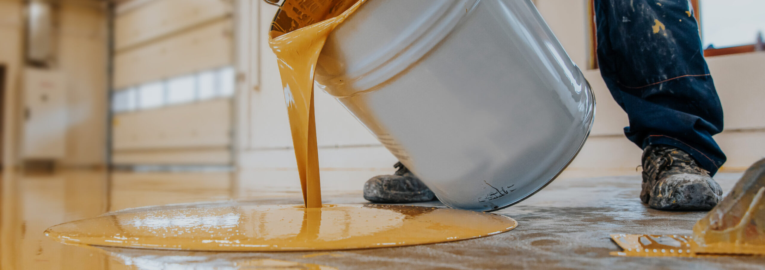 Worker,Applying,A,Yellow,Epoxy,Resin,Bucket,On,Floor.